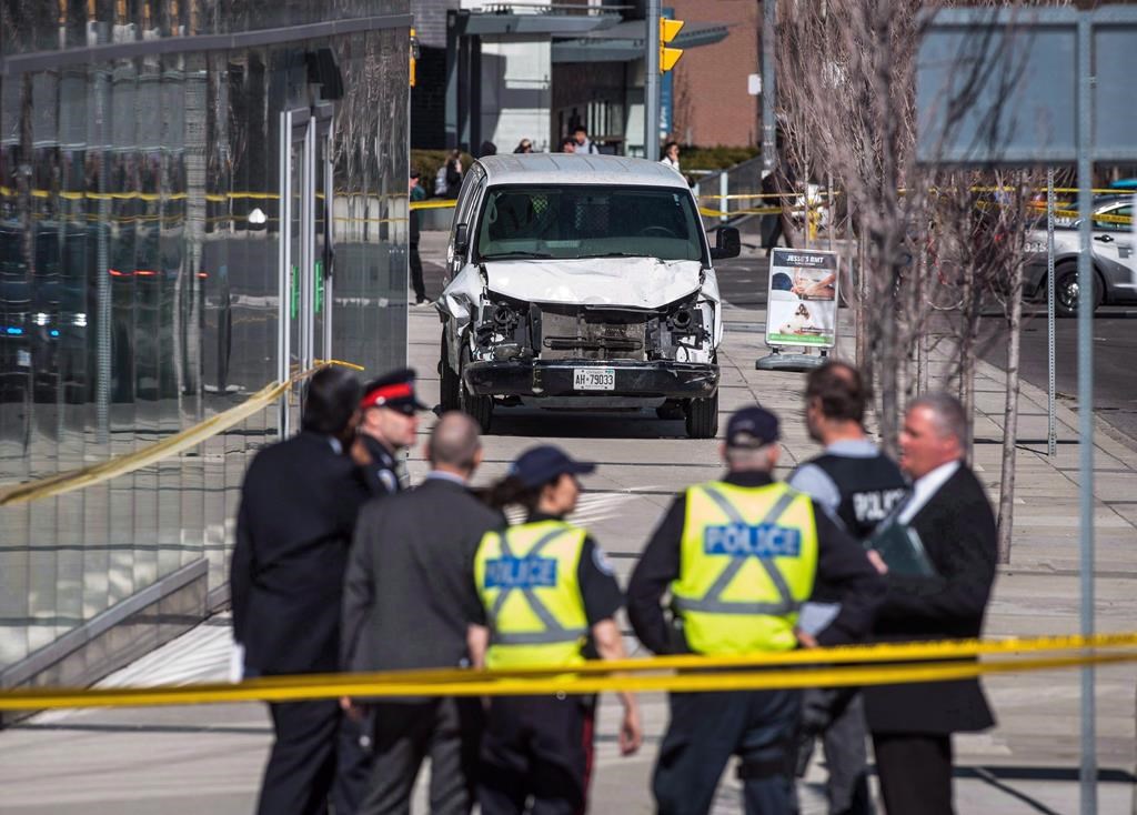 Police are seen near a damaged van in Toronto after a van mounted a sidewalk crashing into a number of pedestrians on Monday, April 23, 2018. The Supreme Court of Canada has dismissed a request to keep some information barred from public view in the Toronto van attack case.THE CANADIAN PRESS/Aaron Vincent Elkaim.