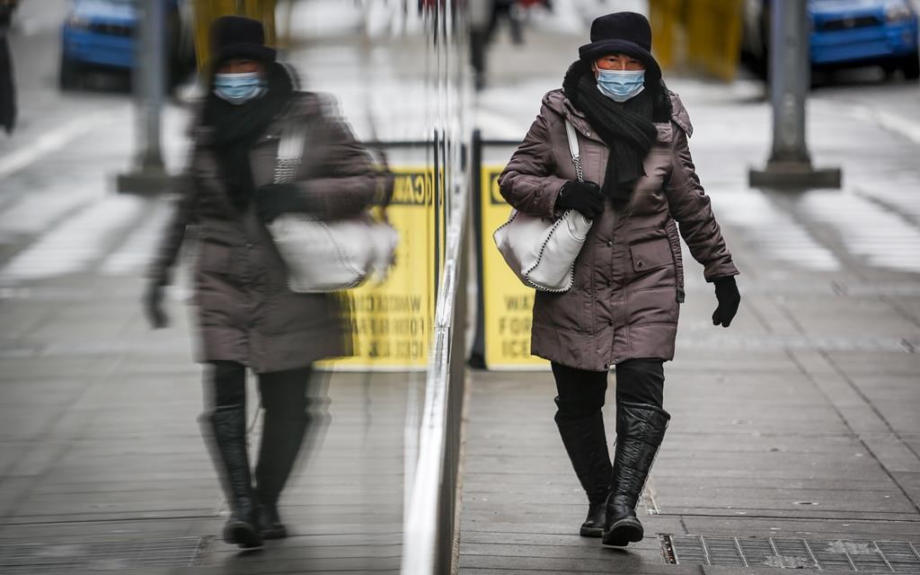 A pedestrian wearing a mask walks through an empty downtown Calgary on Wednesday, Dec. 9, 2020.