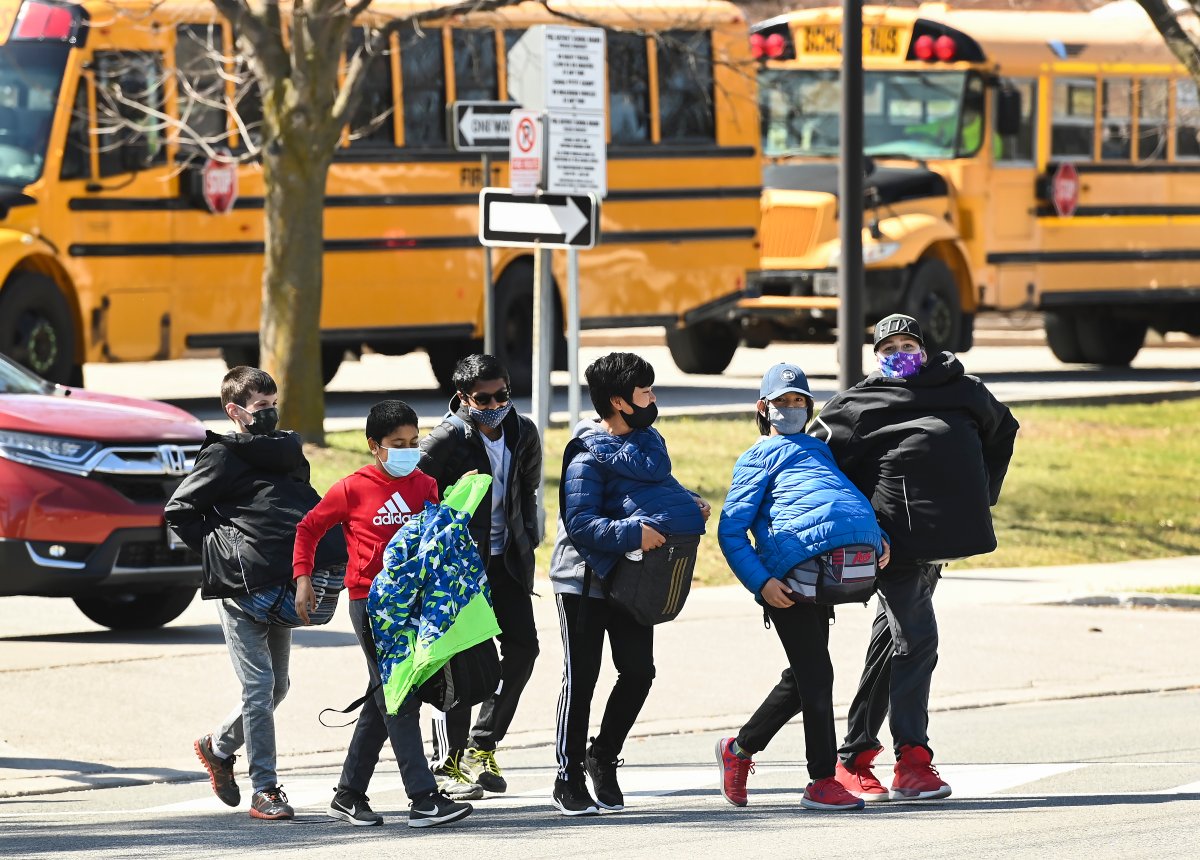 Students cross the street at Tomken Road Middle School as Ontario prepares for its third province wide lockdown during the COVID-19 pandemic in Mississauga, Ont., on Thursday, April 1, 2021. Schools will remain open during the four week emergency brake lockdown. THE CANADIAN PRESS/Nathan Denette.