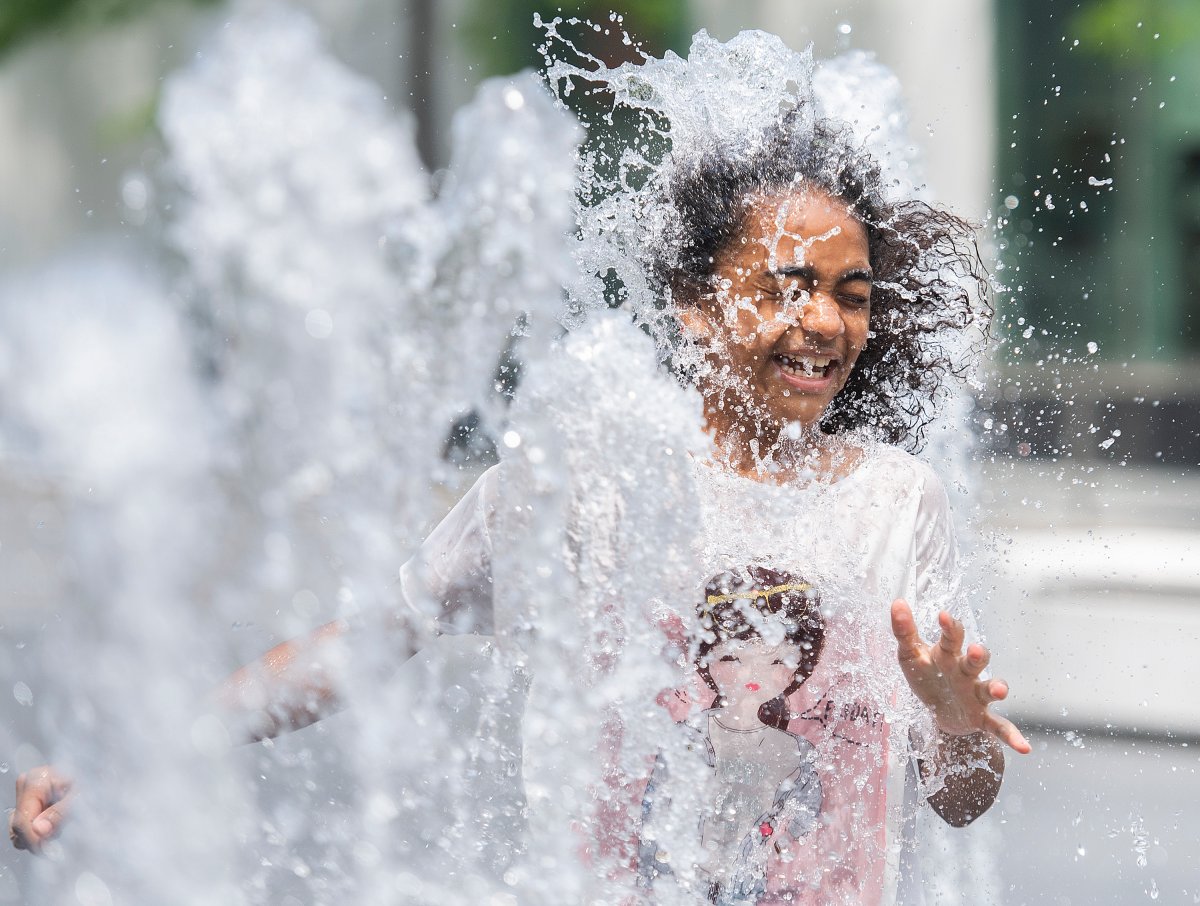 Emily Adejor (10) beats the heat as she runs through a water fountain. Sunday, June 6, 2021.
