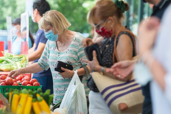 People wear face masks as they shop at a market