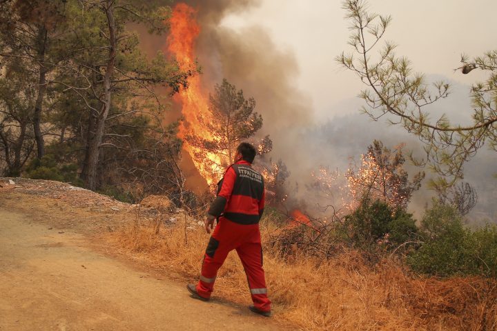 Firefighters work in the smoke-engulfed Mazi area as wildfires rolled down the hill toward the seashore, forcing people to be evacuated, in Bodrum, Mugla, Turkey, Sunday, Aug. 1, 2021.