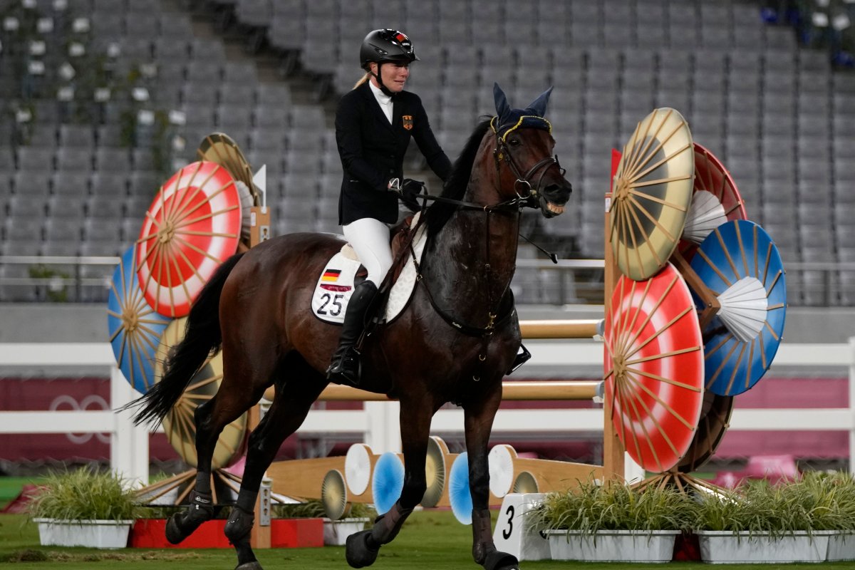 Annika Schleu of Germany cries, unable to control her horse to compete in the equestrian portion of the women's modern pentathlon at the 2020 Summer Olympics, Aug. 6, 2021, in Tokyo, Japan.
