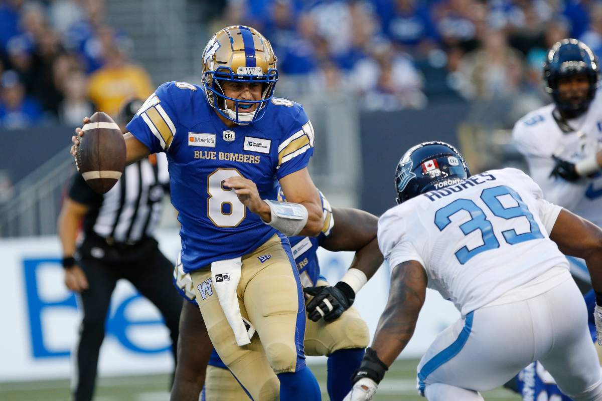 Winnipeg Blue Bombers quarterback Zach Collaros (8) scrambles away from Toronto Argonauts' Charleston Hughes (39) during the first half of CFL action in Winnipeg Friday, August 13.