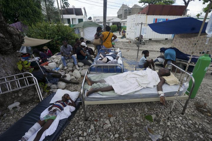 Injured people lie in beds outside the Immaculee Conception hospital in Les Cayes, Haiti, Monday, Aug. 16, 2021