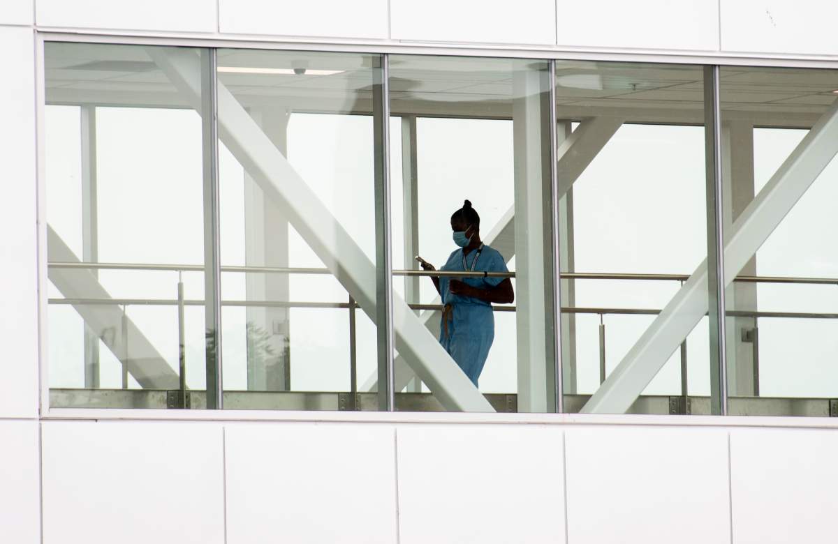 A healthcare worker crosses a covered overhead walkway at a hospital in Montreal, Tuesday, August 17, 2021, as the COVID-19 pandemic continues in Canada and around the world. 
