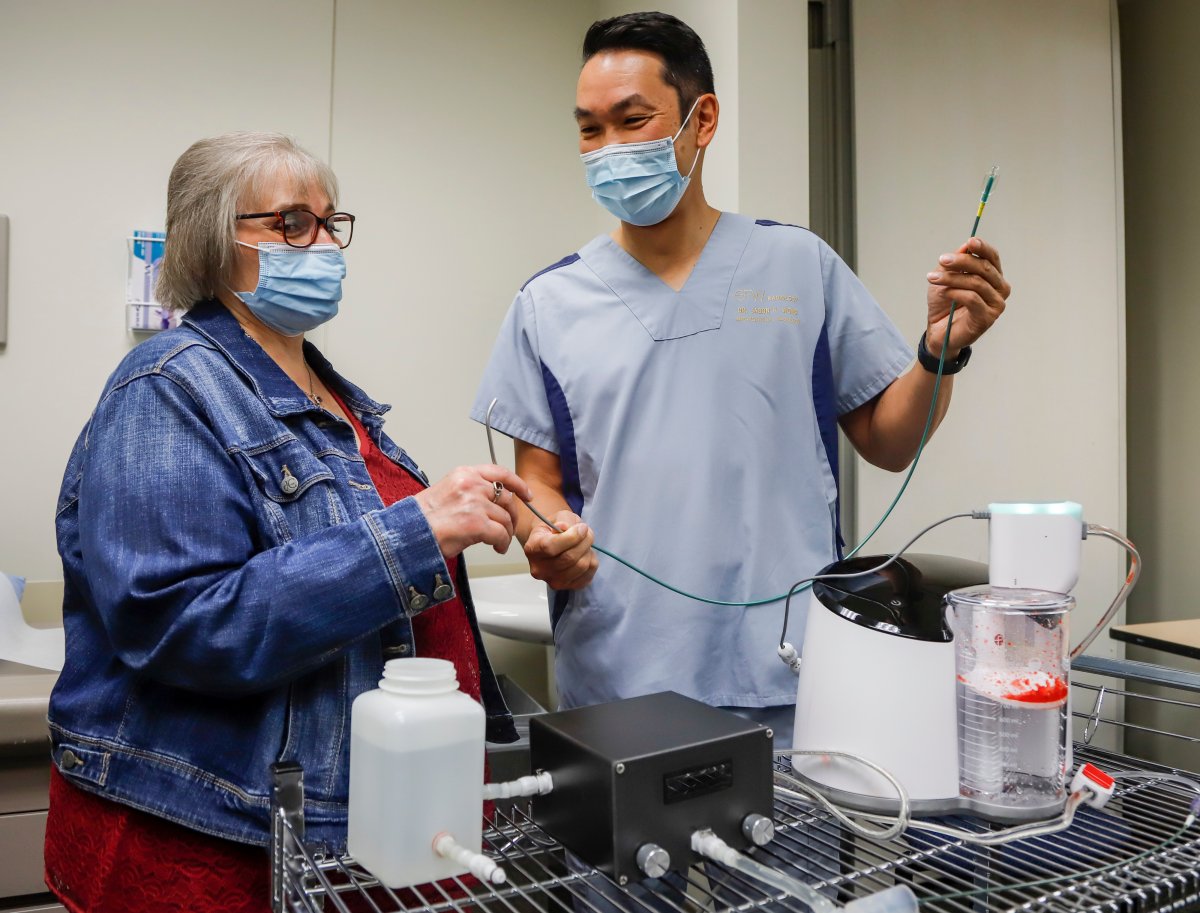 Brenda Crowell, left, and Dr. Jason Wong, display a CAT12 device, which Wong used to save Crowell's life after she developed a deadly blood clot caused by COVID-19, in Calgary, Alta., Thursday, Aug. 19, 2021. 