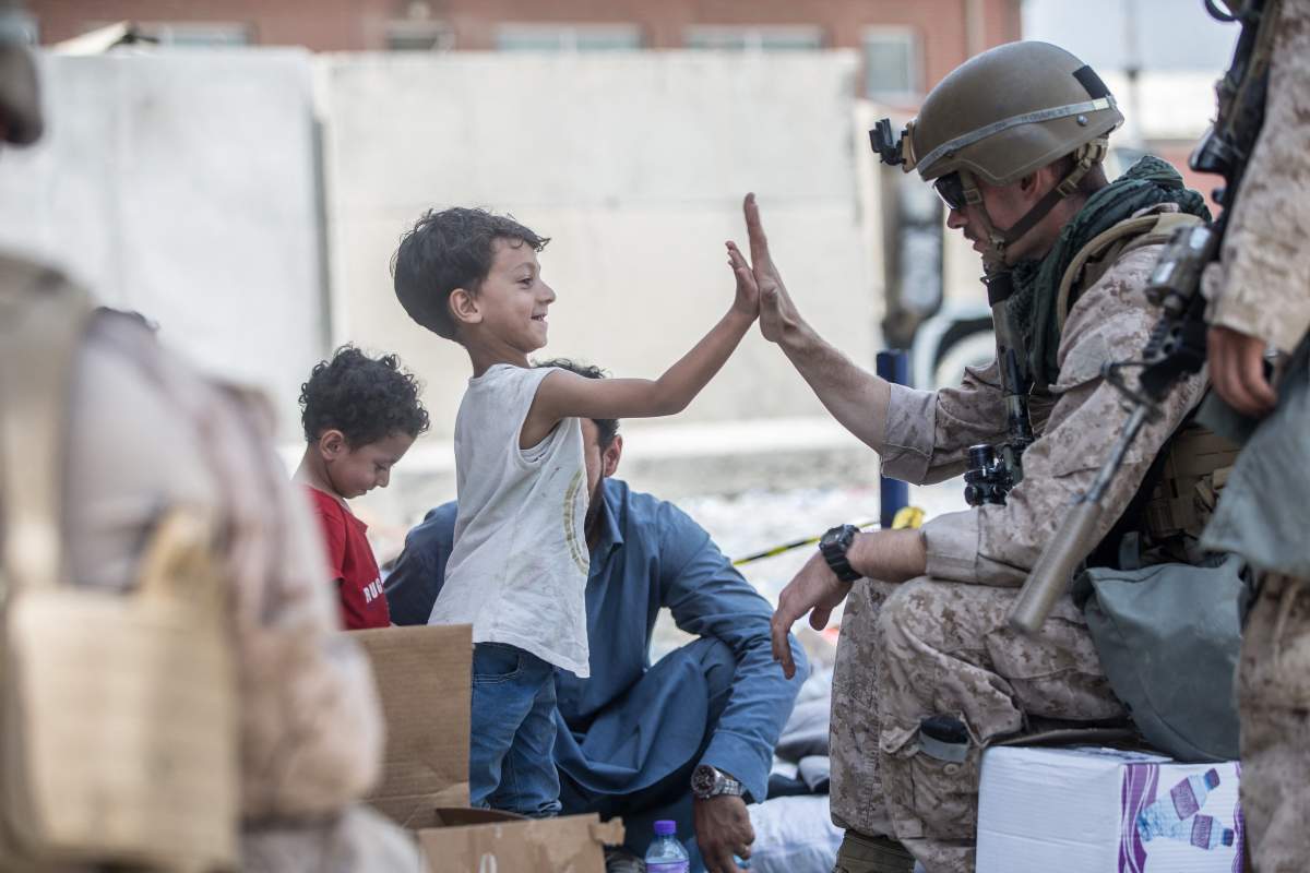 A Marine plays with a kid during evacuation operations at Hamid Karzai International Airport, Kabul, Afghanistan, on August 22, 2021, in the days following the fall of Kabul to Taliban movement, amid chaos and panic scenes at the capitalâÂ€Â™s airport. Photo by CENTCOM-Balkis Press/ABACAPRESS.COM