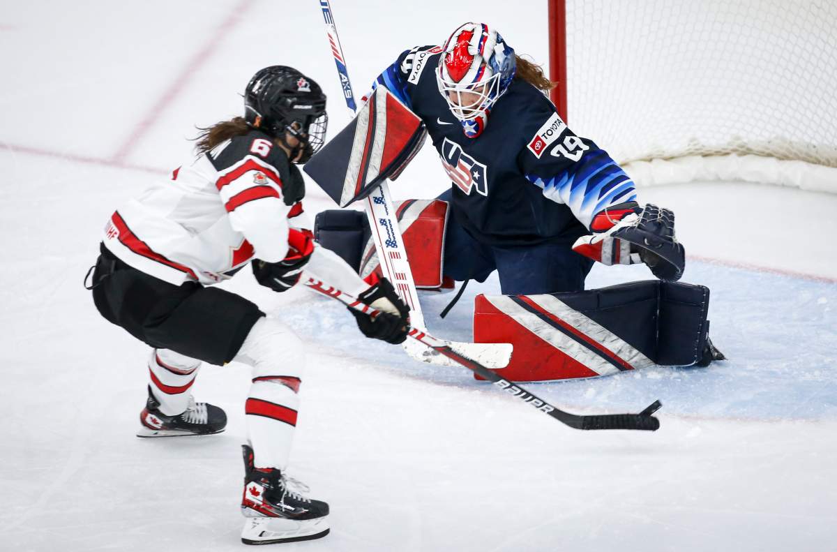 Goalie Nicole Hensley, right, of the United States, reaches for the puck as Canada’s Rebecca Johnston shoots wide during third period IIHF Women’s World Championship hockey action in Calgary, Thursday, Aug. 26, 2021.