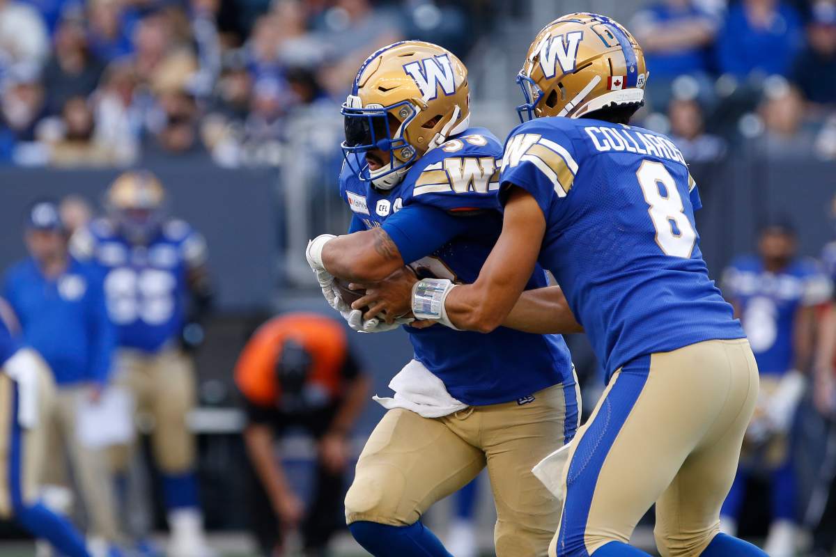 Winnipeg Blue Bombers quarterback Zach Collaros (8) hands off to Andrew Harris (33) against the Calgary Stampeders during first half CFL football action in Winnipeg, Sunday, Aug. 29, 2021.
