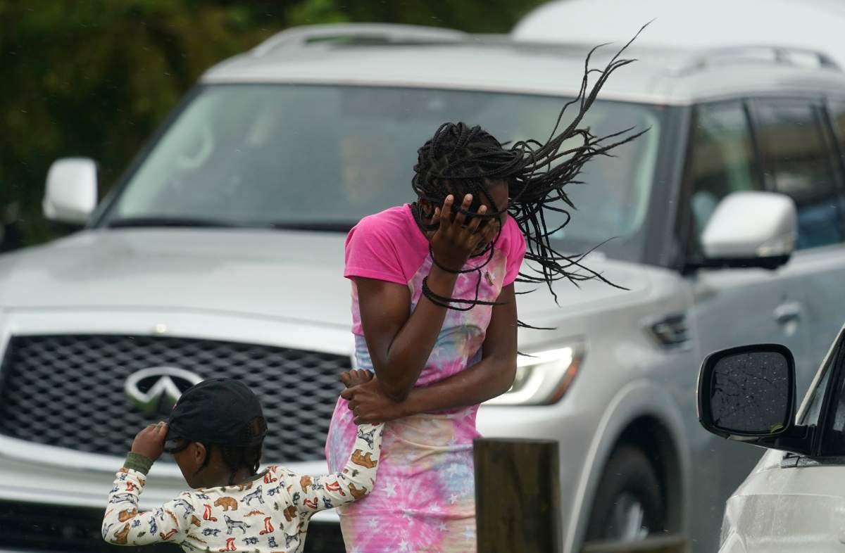 A young girl blocks her face from the wind and rain produced by Hurricane Ida, Sunday, Aug. 29, 2021, in New Orleans, La. (AP Photo/Eric Gay)