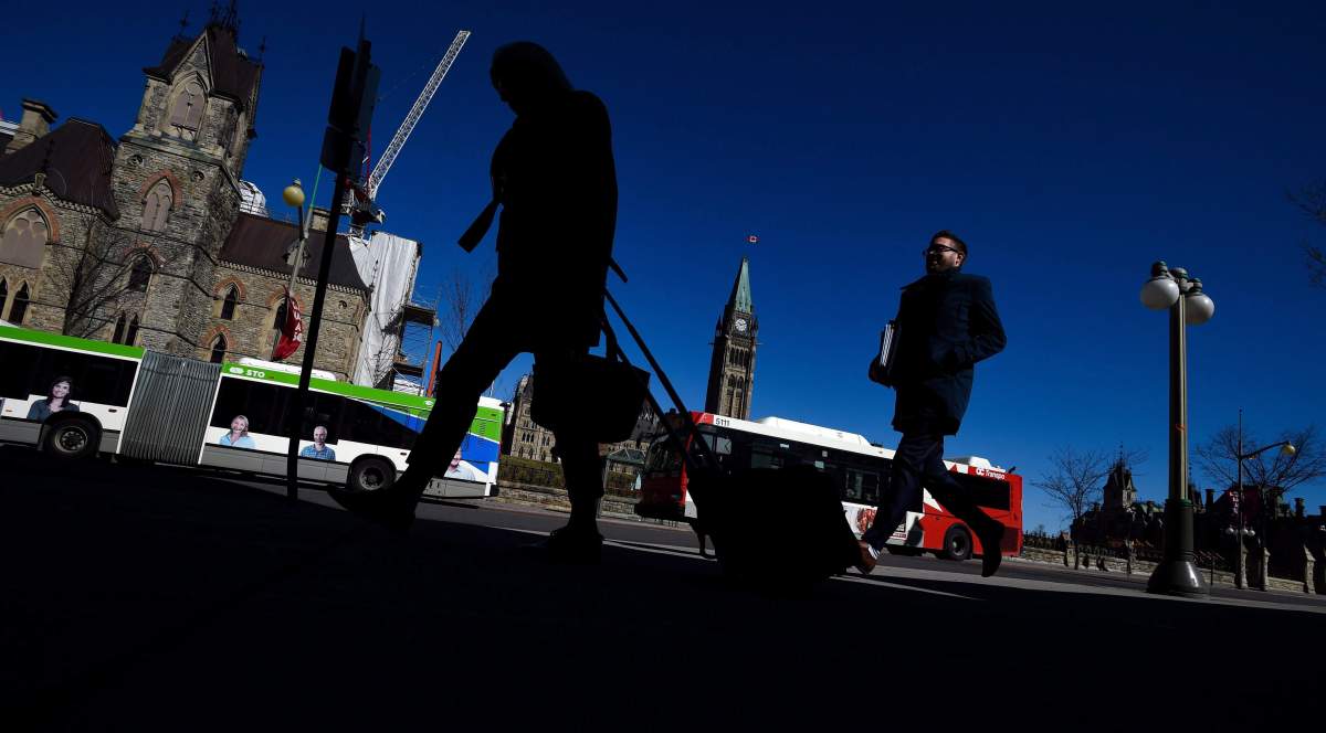 Pedestrians make their way along Wellington Street in Ottawa on Thursday, April 13, 2017. A proposed interprovincial tramway could see the street transformed for at-grade rail.
