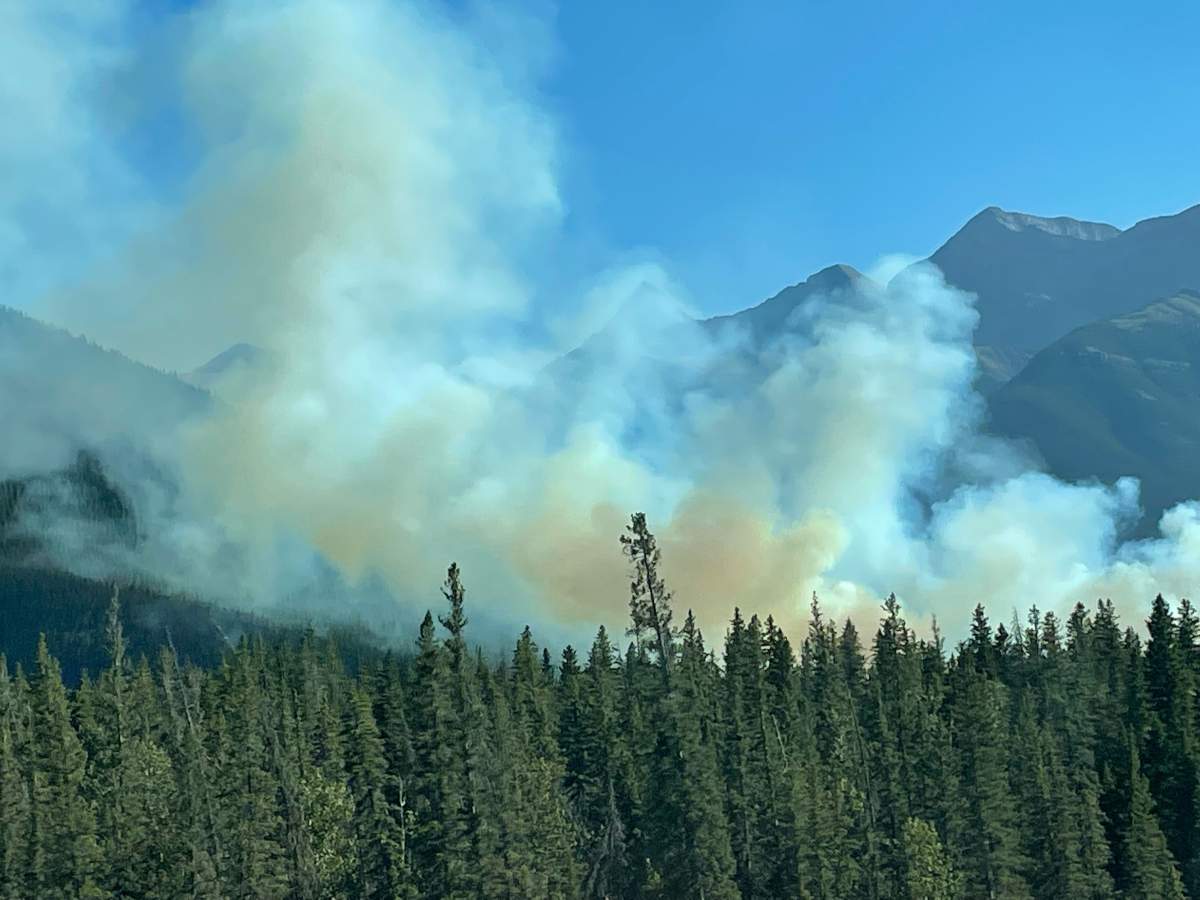 A large plume of smoke is seen coming from a grass fire along Highway 1 near Canmore, Atla., on Friday, Aug. 13.