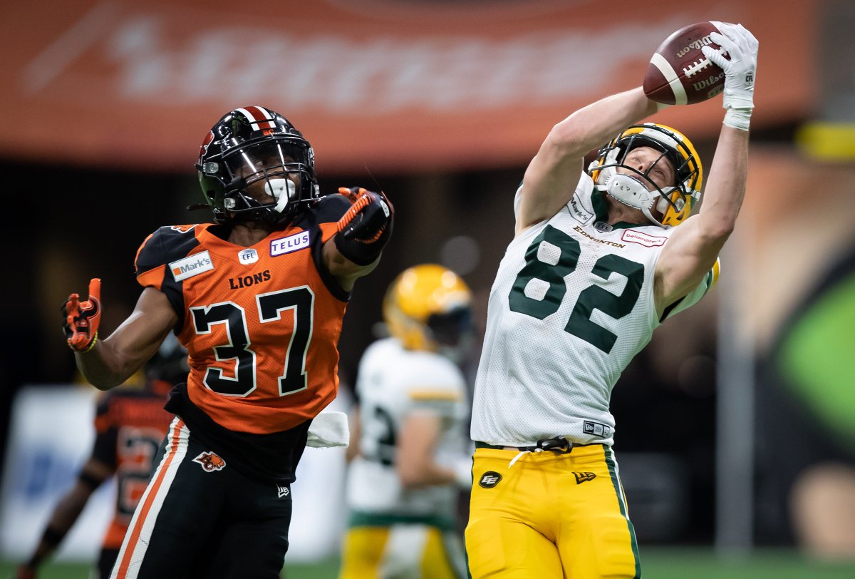 Edmonton Elks' Greg Ellingson (82) makes a reception as B.C. Lions' KiAnte Hardin (37) defends during the second half of a CFL football game in Vancouver, on Thursday August 19, 2021. 
