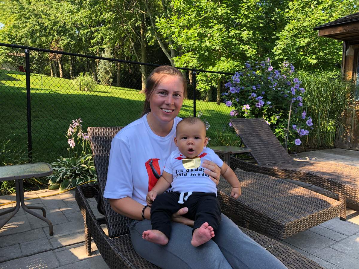 Jen Cotten holds up her four-month-old son Theo, who appears to be still in shock after his father Damian Warner was crowned an Olympic champion.