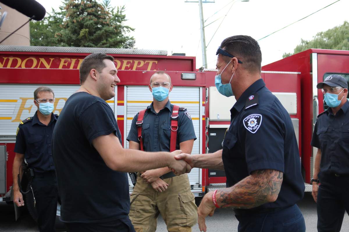 Jacob Hurl shaking the hands of some of the firefighters at Station 3 who helped save his life during the Dec. 11, 2020 partial building collapse at 555 Teeple Terr. in London, Ont., on Aug. 30, 2021