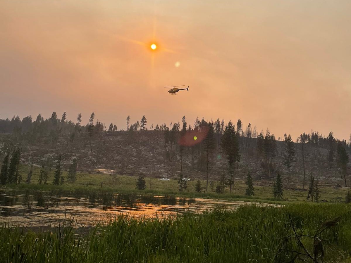 A helicopter delivering water against the White Rock Lake wildfire.