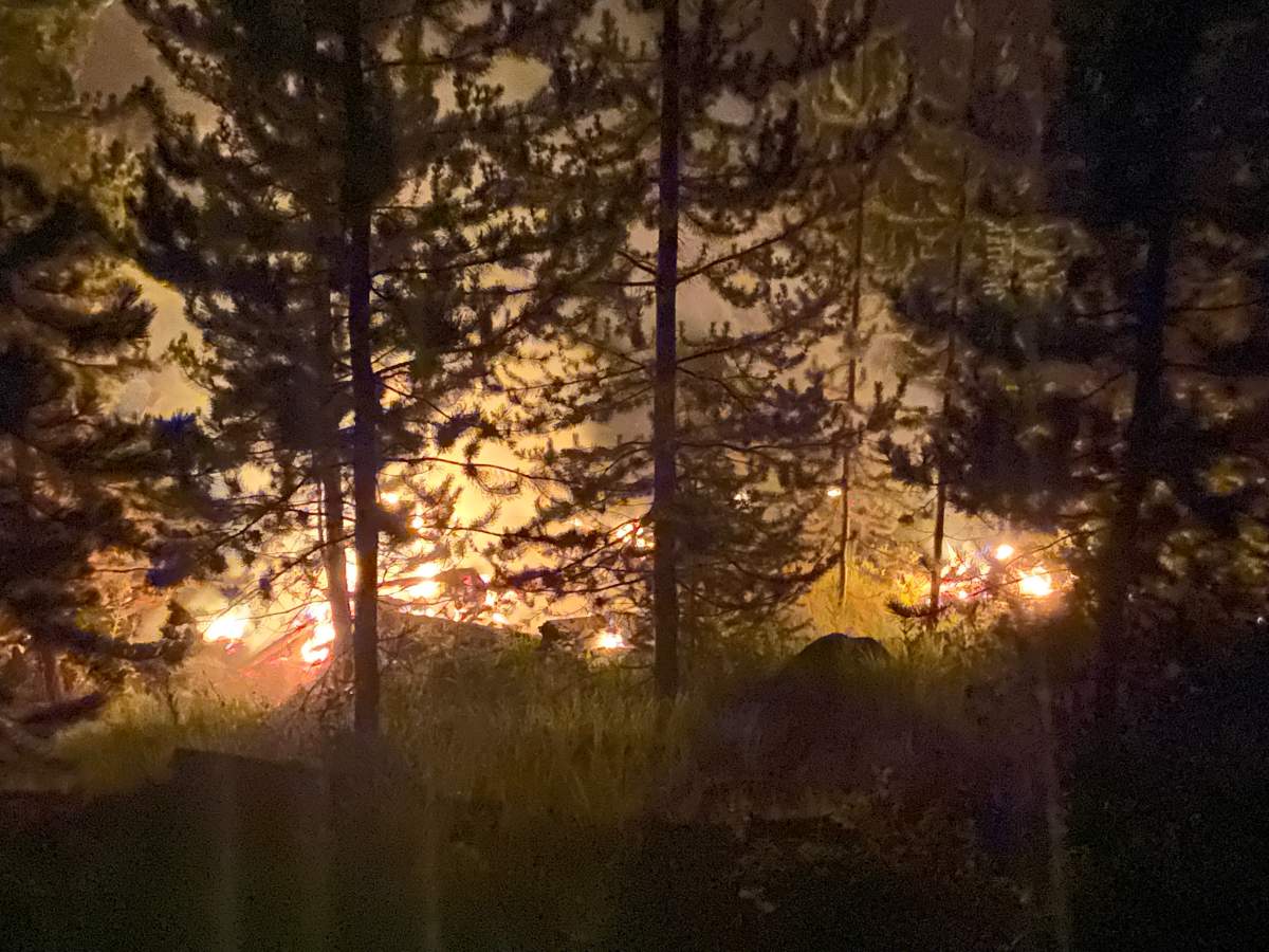 The Garrison Lake wildfire jumped the highway and has prompted some residents to flee their homes. 