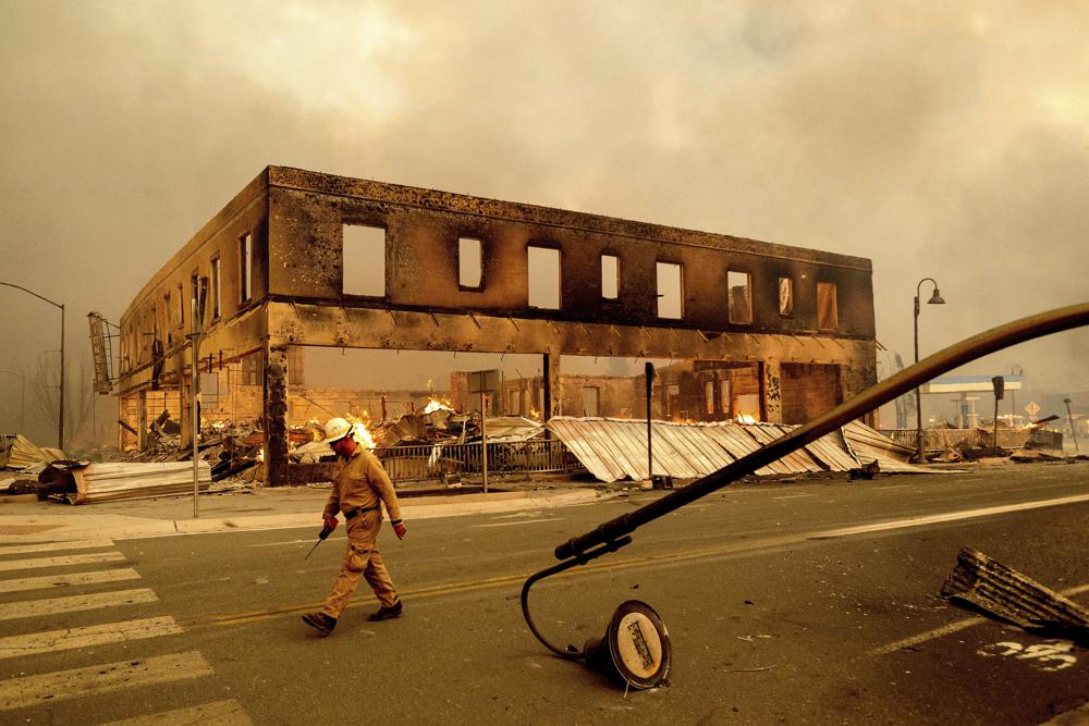 Operations Chief Jay Walter passes the historic Sierra Lodge as the Dixie Fire burns through the Greenville community of Plumas County, Calif., on Wednesday, Aug. 4, 2021. The fire leveled multiple historic buildings and dozens of homes in central Greenville.