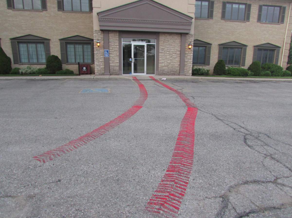 Red paint made to look like tank tracks outside MP Kate Young’s office on Aug. 9, 2021.