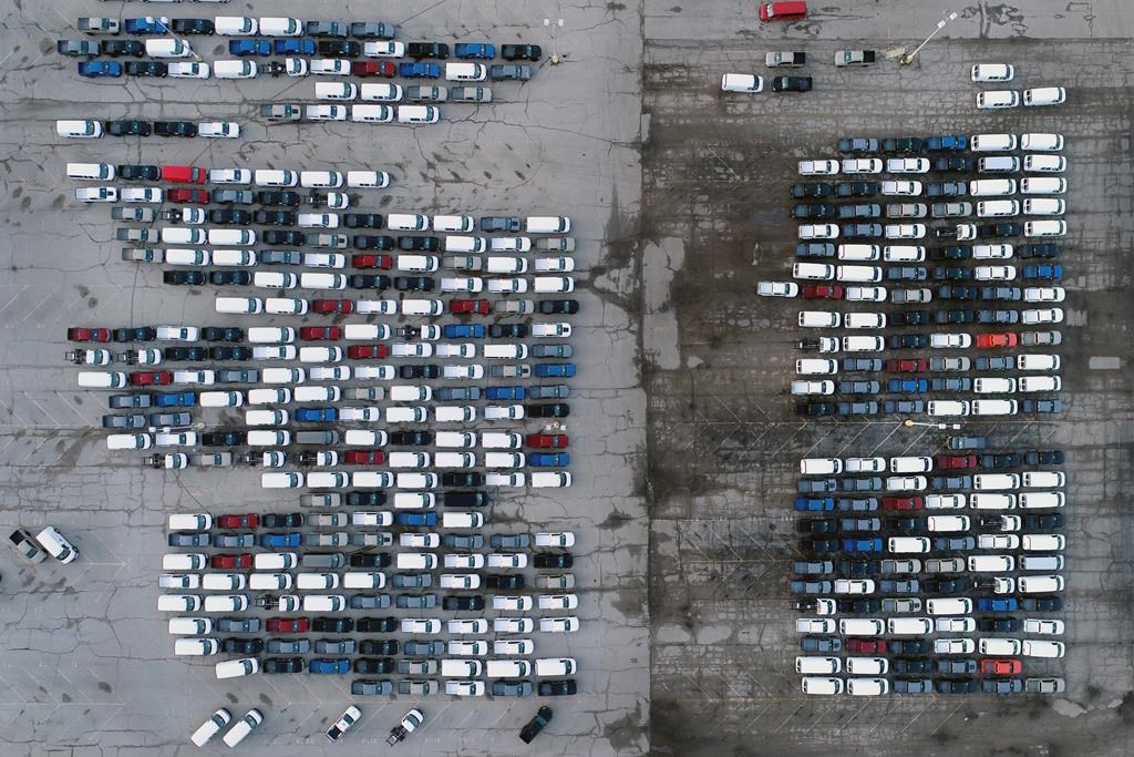 FILE - In this March 24, 2021 file photo, mid-sized pickup trucks and full-size vans are seen in a parking lot outside a General Motors assembly plant where they are produced in Wentzville, Mo.