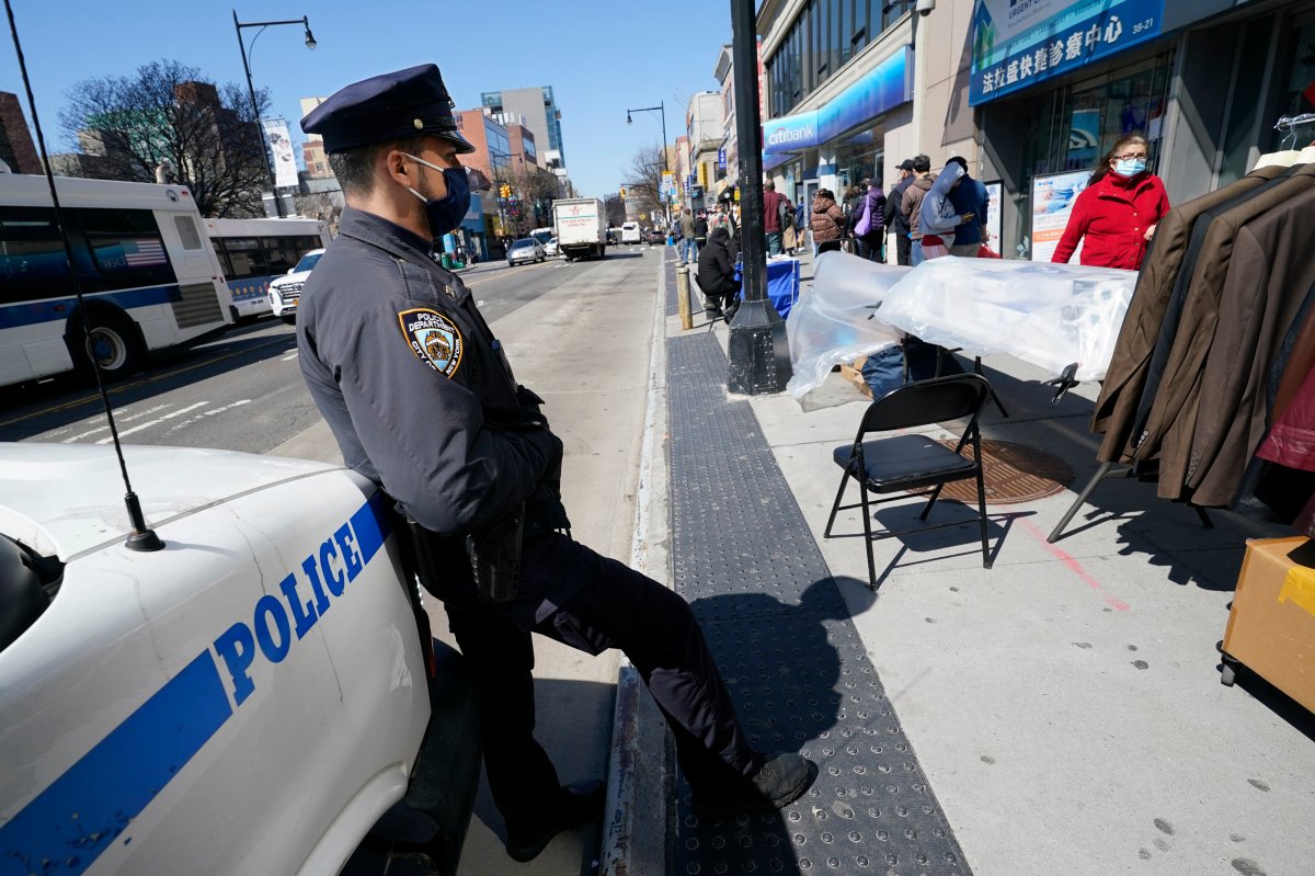 New York Police Department Officer Rodney Hierro keeps an eye on pedestrians walking on Main Street in Flushing, a heavily Asian neighborhood, Tuesday, March 30, 2021, in the Queens borough of New York.