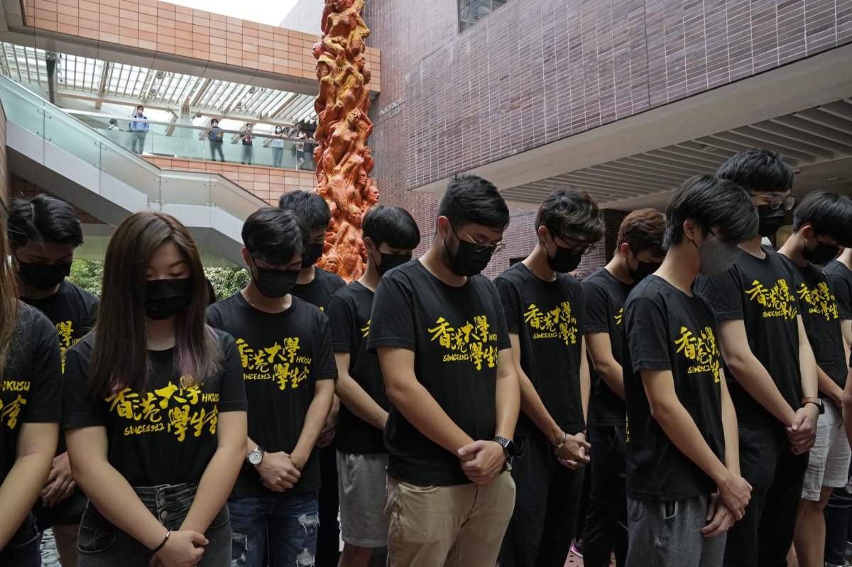 University students observe one minute silence to mourn those killed in the 1989 Tiananmen crackdown, in front of the "Pillar of Shame" statue at the University of Hong Kong, Friday, June 4, 2021. Police arrested an organizer of Hong Kong's annual candlelight vigil remembering the deadly Tiananmen Square crackdown and warned people not to attend the banned event Friday as authorities mute China's last pro-democracy voices. (AP Photo/Kin Cheung).