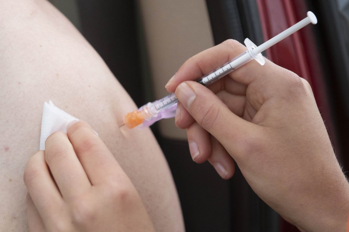 A person receives their COVID-19 vaccine during a drive-thru clinic at Richardson stadium in Kingston, Ont., on Friday, Jul. 2, 2021.