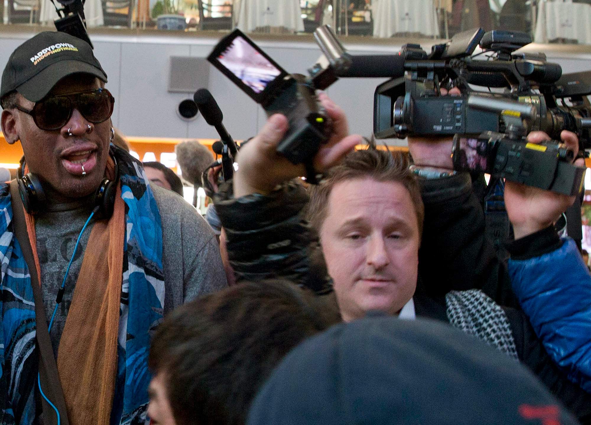 FILE – In this Dec. 19, 2013, file photo, Michael Spavor, center, an entrepreneur, is seen with former NBA star Dennis Rodman, left, on the arrival at the capital airport for a flight to North Korea, in Beijing, China. (AP Photo/Ng Han Guan, File)