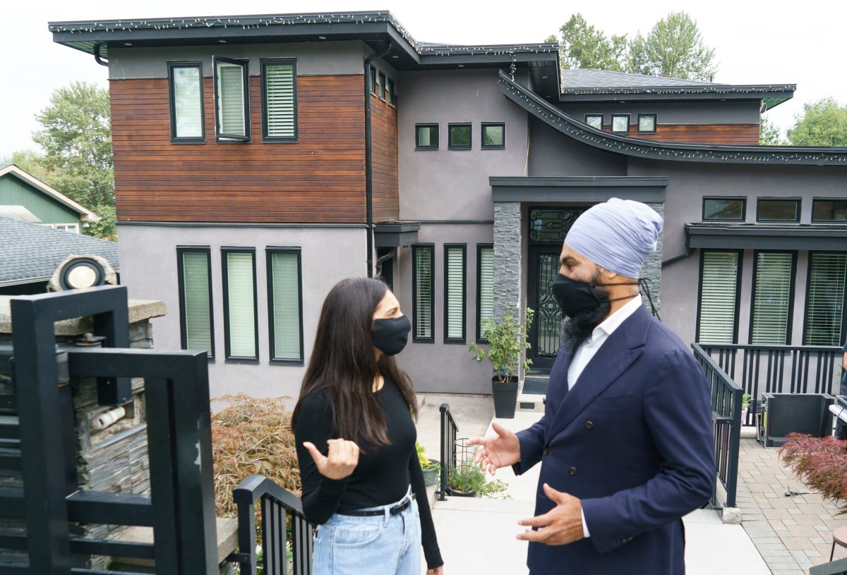 NDP Leader Jagmeet Singh chats with Jasleen Arora as he leaves a house following a news conference on affordable housing in Burnaby, B.C., on Wednesday, August 18, 2021. 