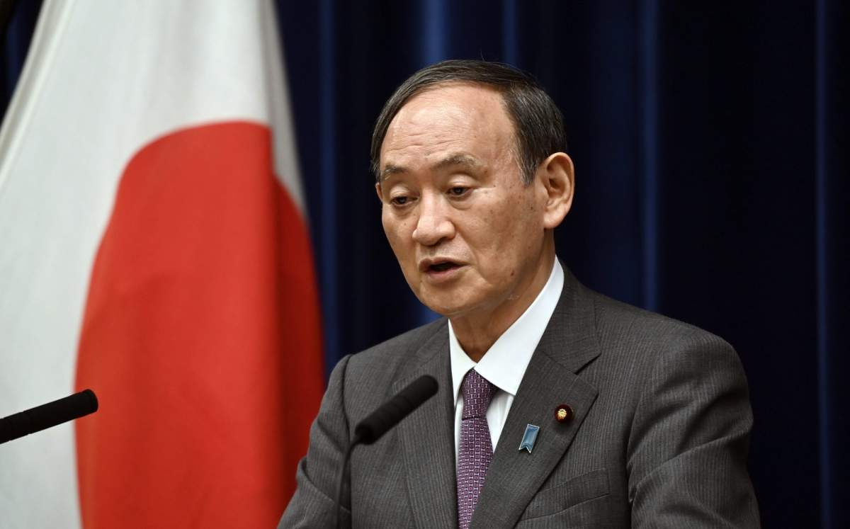 Japan's Prime Minister Yoshihide Suga attends a news conference with chairman of the government's pandemic advisory panel Shigeru Omi, not pictured, at the prime minister's official residence in Tokyo, Wednesday, Aug. 25, 2021. Japan has expanded its coronavirus state of emergency for a second week in a row, adding eight more prefectures as a surge in infections fueled by the delta variant strains the country’s health care system. (Kazuhiro Nogi/Pool photo via AP).