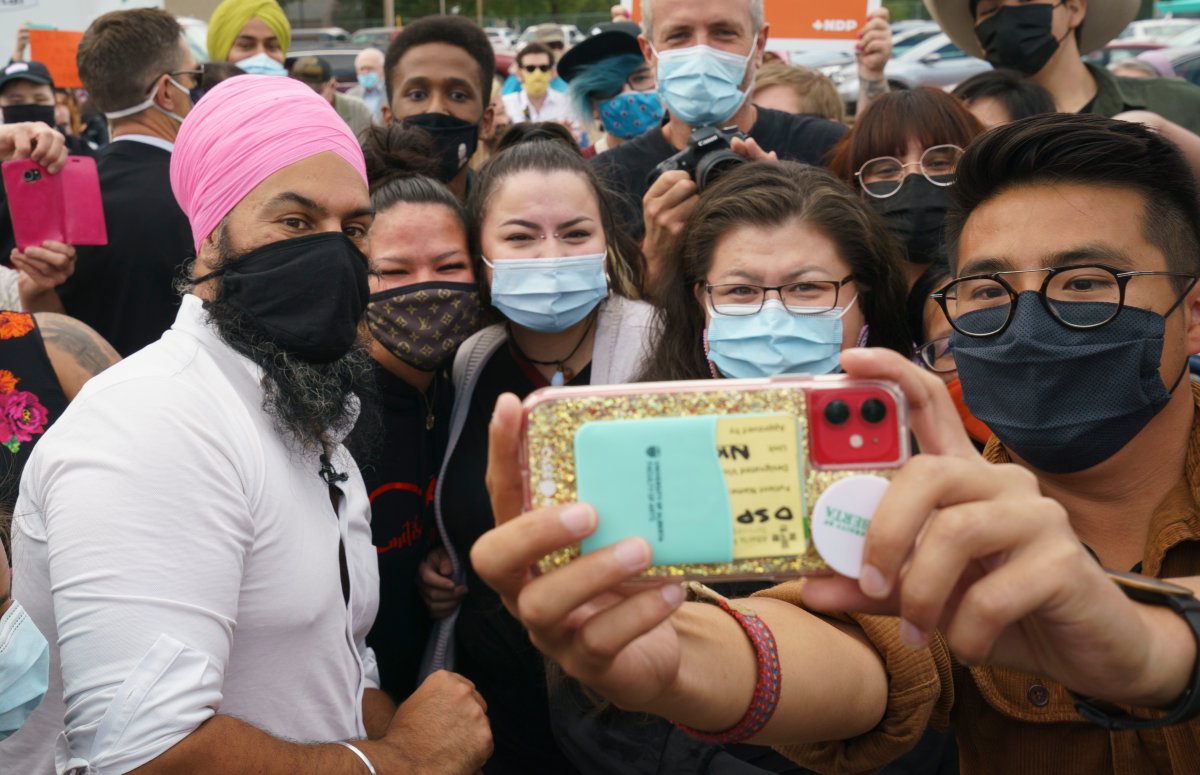 Local candidate Blake Desjarlais, right, takes a souvenir photo of NDP leader Jagmeet Singh and supporters during a campaign rally in Edmonton, on Thursday, August 19, 2021.