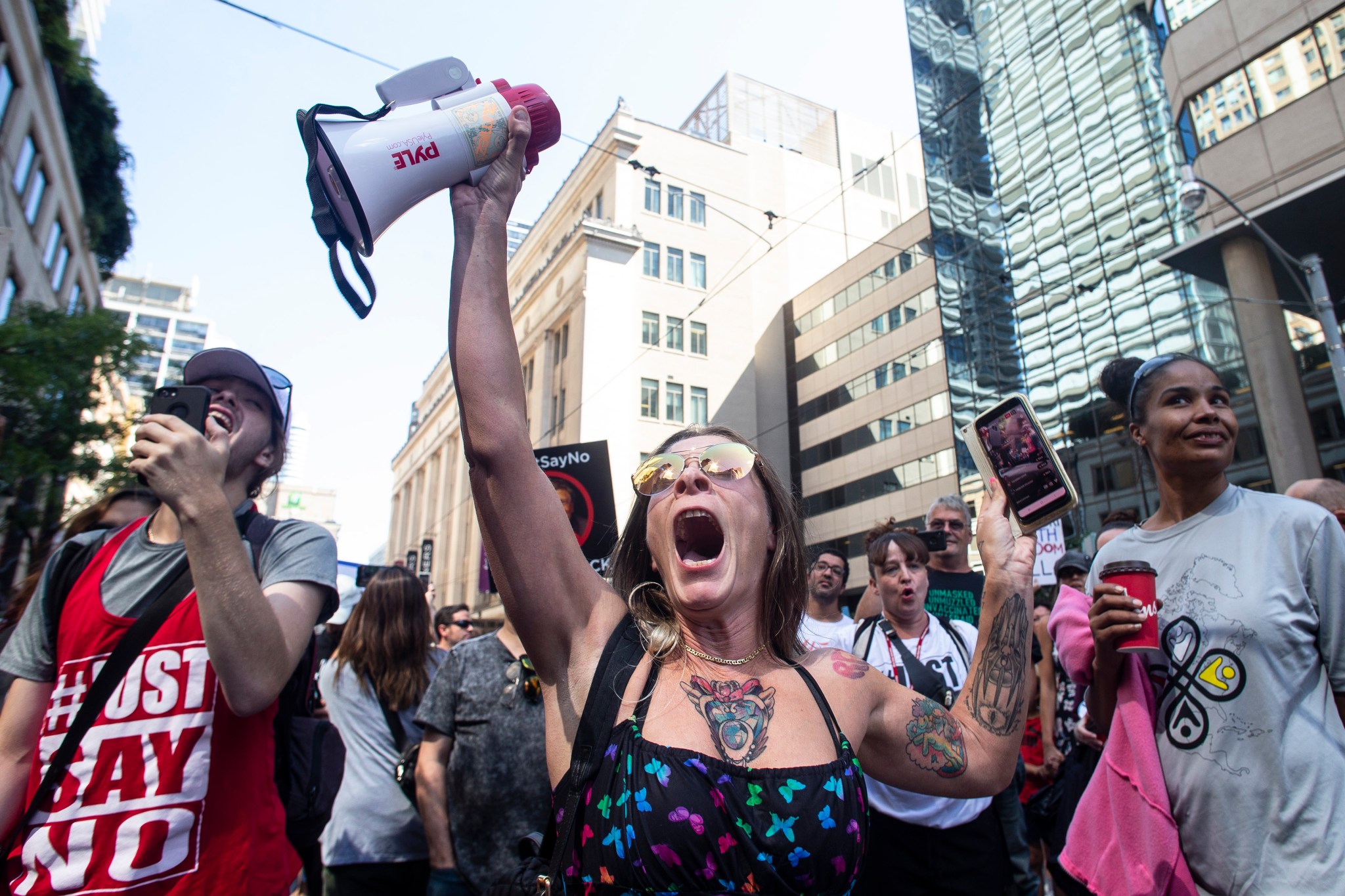 Protesters listen to a speaker as they gather outside Toronto Police Headquarters to voice opposition to COVID-19 vaccines and other COVID-19 related restrictions on Thursday September 2, 2021. THE CANADIAN PRESS/Chris Young.