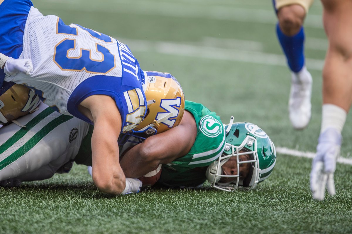 Saskatchewan Roughriders running back Jamal Morrow (25) gets tackled to the ground by Winnipeg Blue Bombers' Noah Hallett (23) during first half CFL football action in Regina, Sunday, Sept. 5, 2021.