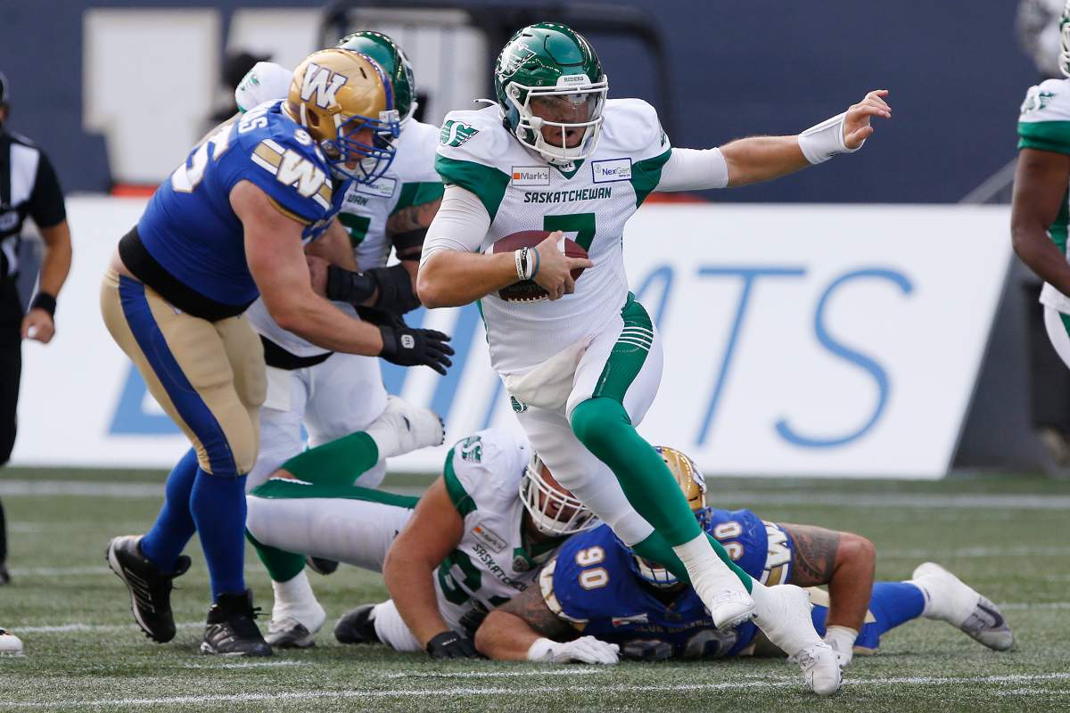 Saskatchewan Roughriders quarterback Cody Fajardo (7) scrambles for the first down during the first half of CFL action against the Winnipeg Blue Bombers in Winnipeg, Saturday, Sept. 11, 2021.