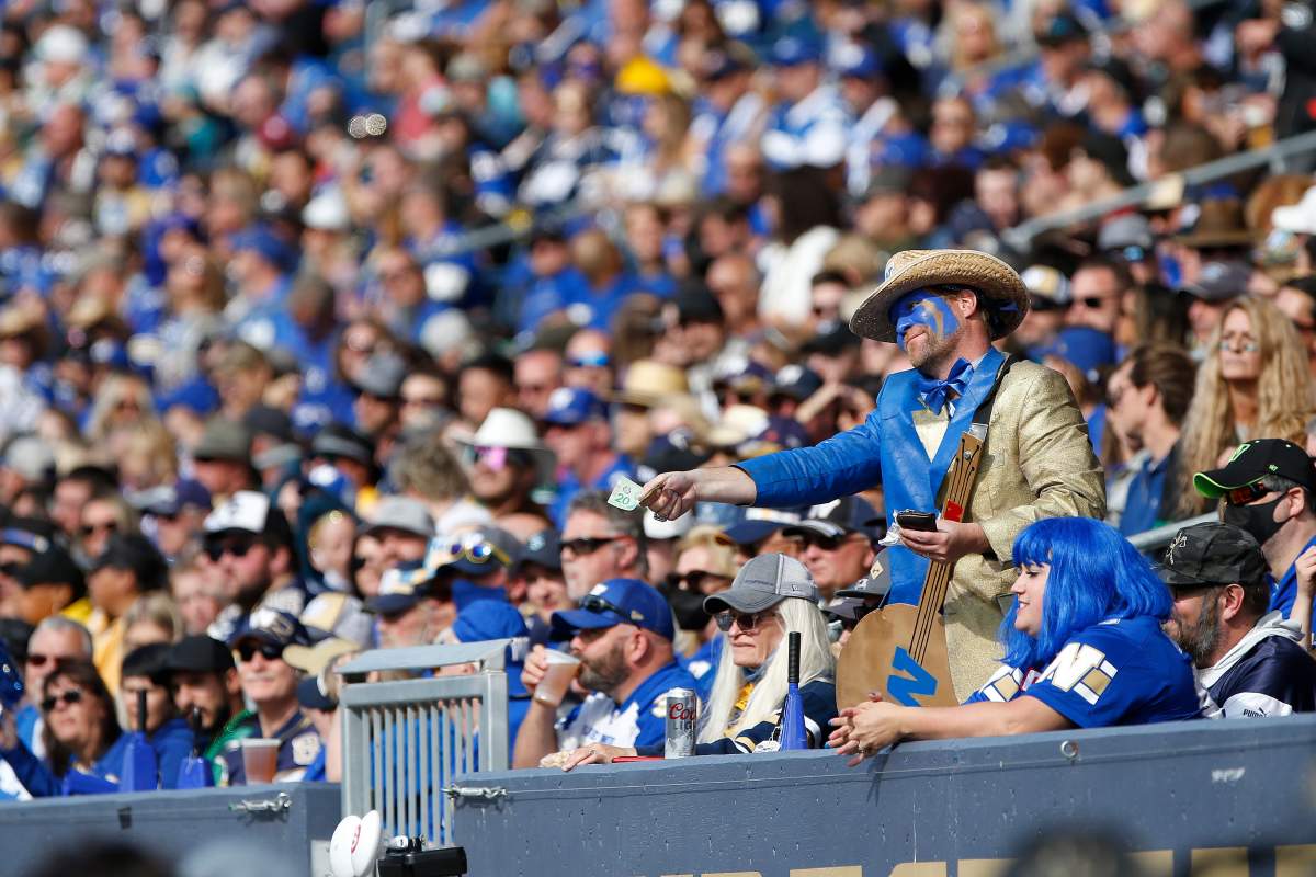 Winnipeg Blue Bombers’ fan offers the Saskatchewan Roughriders’ bench $20 during first half CFL action in Winnipeg, Saturday, Sept. 11, 2021.