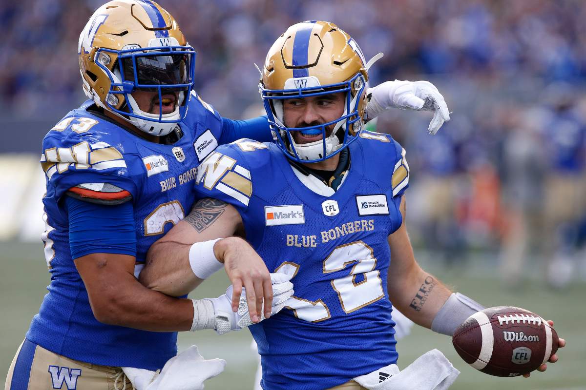 Winnipeg Blue Bombers quarterback Sean McGuire (12) and Andrew Harris (33) celebrate McGuire’s touchdown against the Saskatchewan Roughriders during first half CFL action in Winnipeg, Saturday, Sept. 11, 2021.