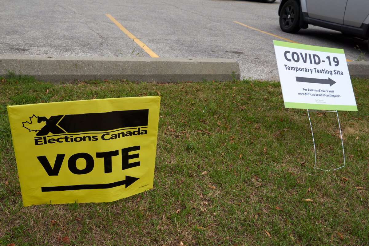 A sign for a COVID-19 testing site sits in close proximity to an Elections Canada polling station “VOTE” sign, at an advance polling station for the 2021 federal election, at the East York Community Centre in Toronto on Sept. 12, 2021. 
