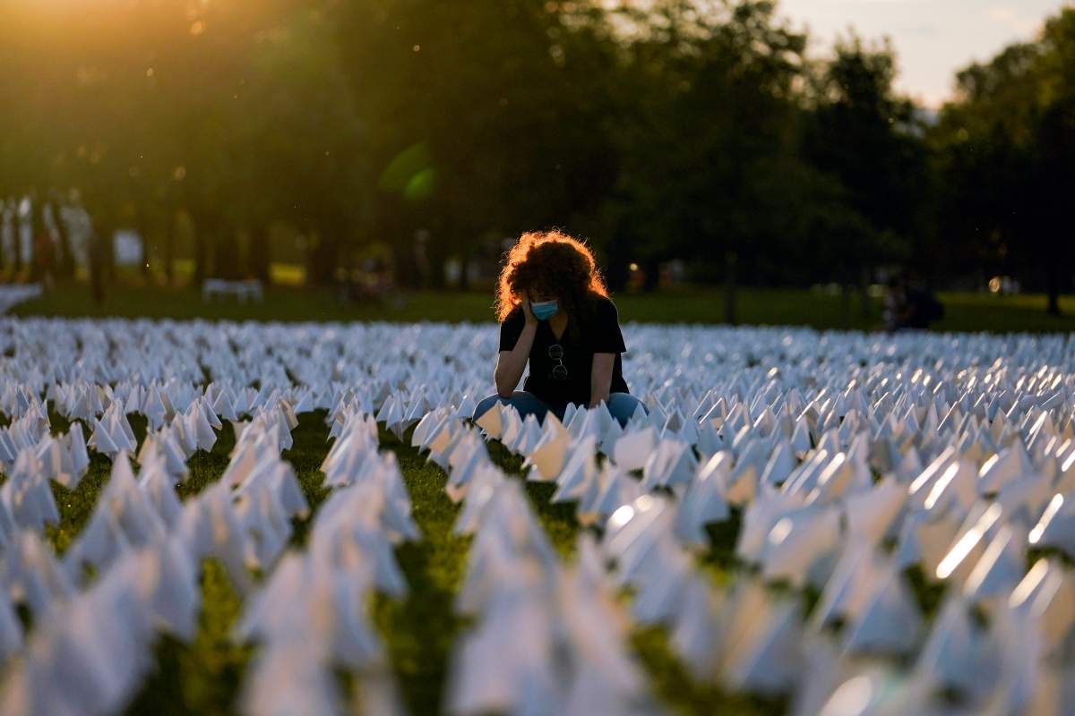 Zoe Nassimoff, of Argentina, looks at white flags that are part of artist Suzanne Brennan Firstenberg’s temporary art installation, “In America: Remember,” in remembrance of Americans who have died of COVID-19, on the National Mall in Washington, Friday, Sept. 17, 2021. Nassimoff’s grandparent who lived in Florida died from COVID-19. (AP Photo/Brynn Anderson)