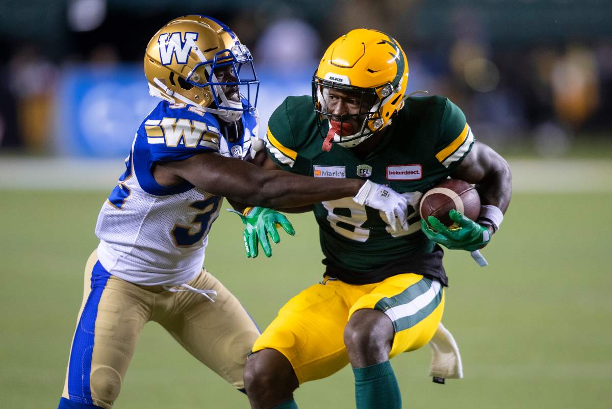 Winnipeg Blue Bombers' Deatrick Nichols (32) tries to tackle Edmonton Elks' Trumaine Washington (8) during first half CFL action in Edmonton, Alta., on Saturday, September 18, 2021.