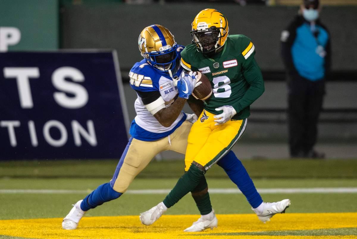 Winnipeg Blue Bombers’ Darvin Adams (1) tries to stop Edmonton Elks’ Trumaine Washington (8) as he makes the interception during first half CFL action in Edmonton, Alta., on Saturday, September 18, 2021.