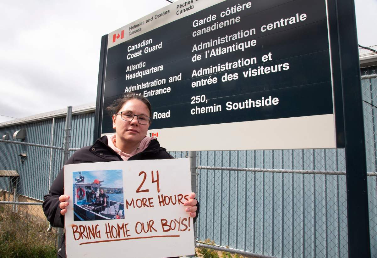 Jade Fowler of Labrador, holds a picture of the two missing men during a demonstration at the Canadian Coast Guard station in St. John’s NL on Monday, September 20, 2021. She was part of a group protesting against the suspension of a search by the Joint Rescue Coordination Centre, after just 48 hours, for two young fishers missing off the coast of Labrador. THE CANADIAN PRESS/Paul Daly