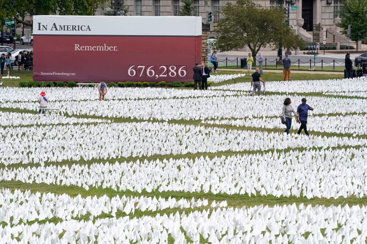People visit artist Suzanne Brennan Firstenberg’s “In America: Remember,” a temporary art installation made up of white flags to commemorate Americans who have died of COVID-19, on the National Mall in Washington, Tuesday, Sept. 21, 2021. (AP Photo/Patrick Semansky)