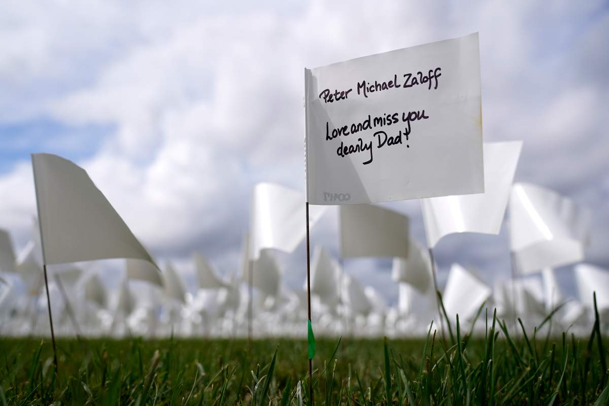 A message marks a white flag that is part of artist Suzanne Brennan Firstenberg’s “In America: Remember,” a temporary art installation to commemorate Americans who have died of COVID-19, on the National Mall in Washington, Tuesday, Sept. 21, 2021. (AP Photo/Patrick Semansky)