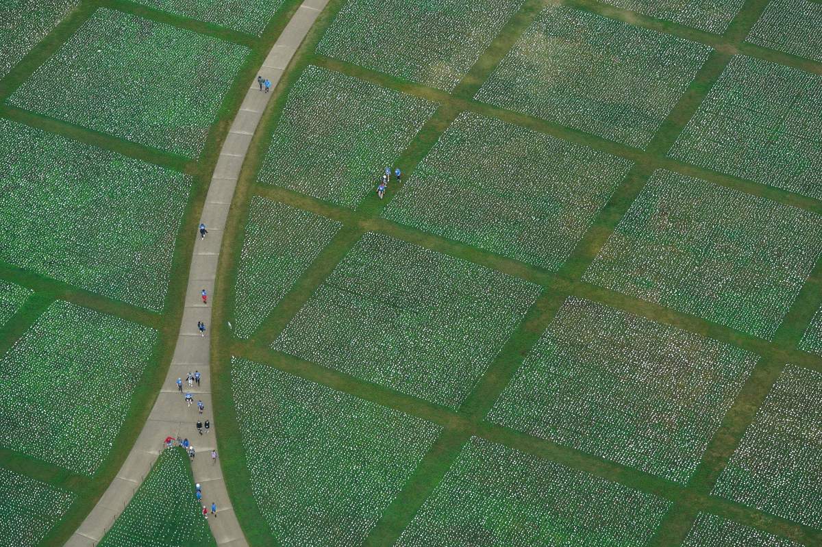 People visit artist Suzanne Brennan Firstenberg’s “In America: Remember,” a temporary art installation made up of white flags to commemorate Americans who have died of COVID-19, on the National Mall in Washington, Wednesday, Sept. 22, 2021. (AP Photo/Patrick Semansky)