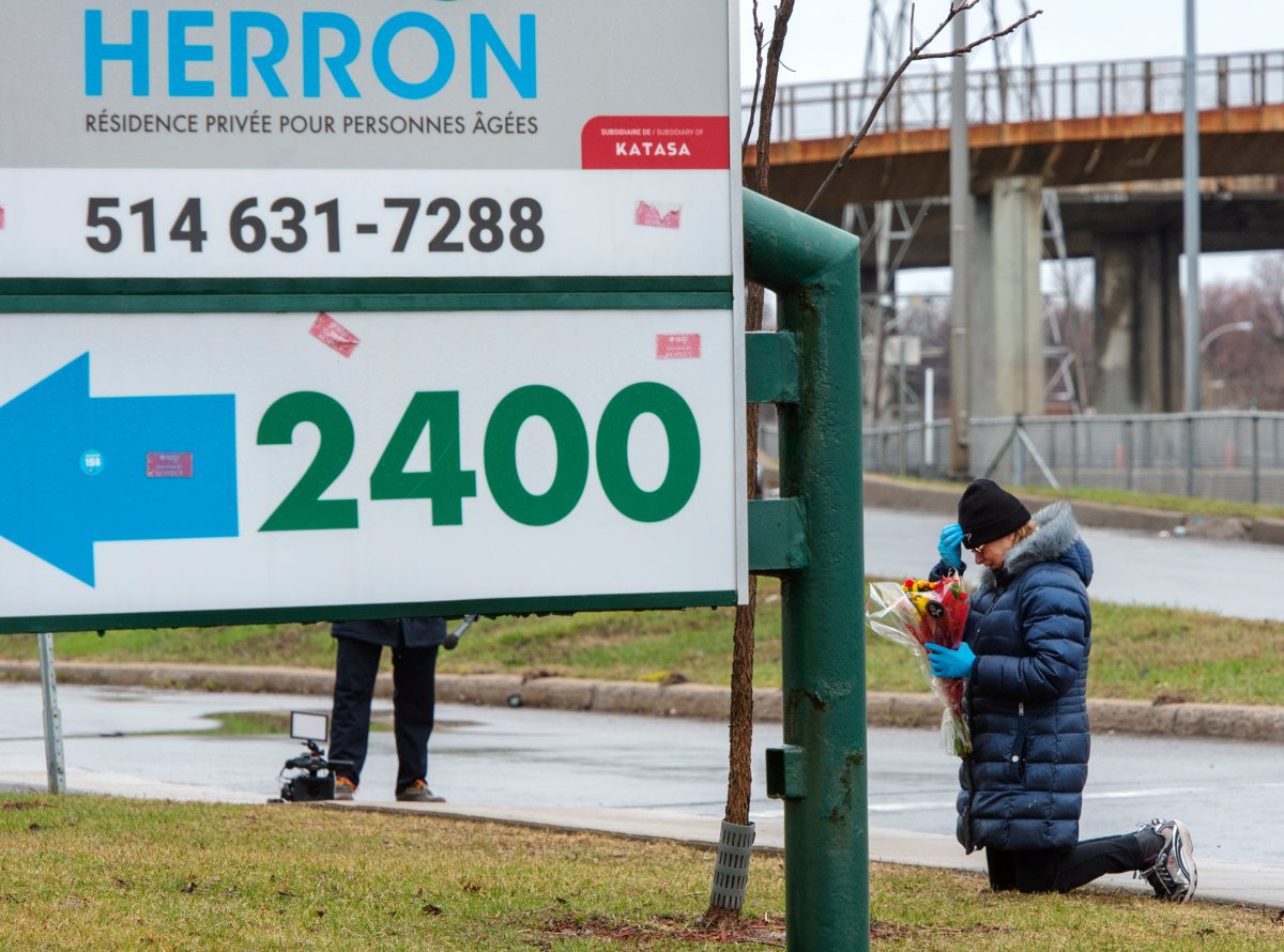 A woman prays in front of the Herron seniors residence Monday April 13, 2020 in Dorval near Montreal's Trudeau airport.