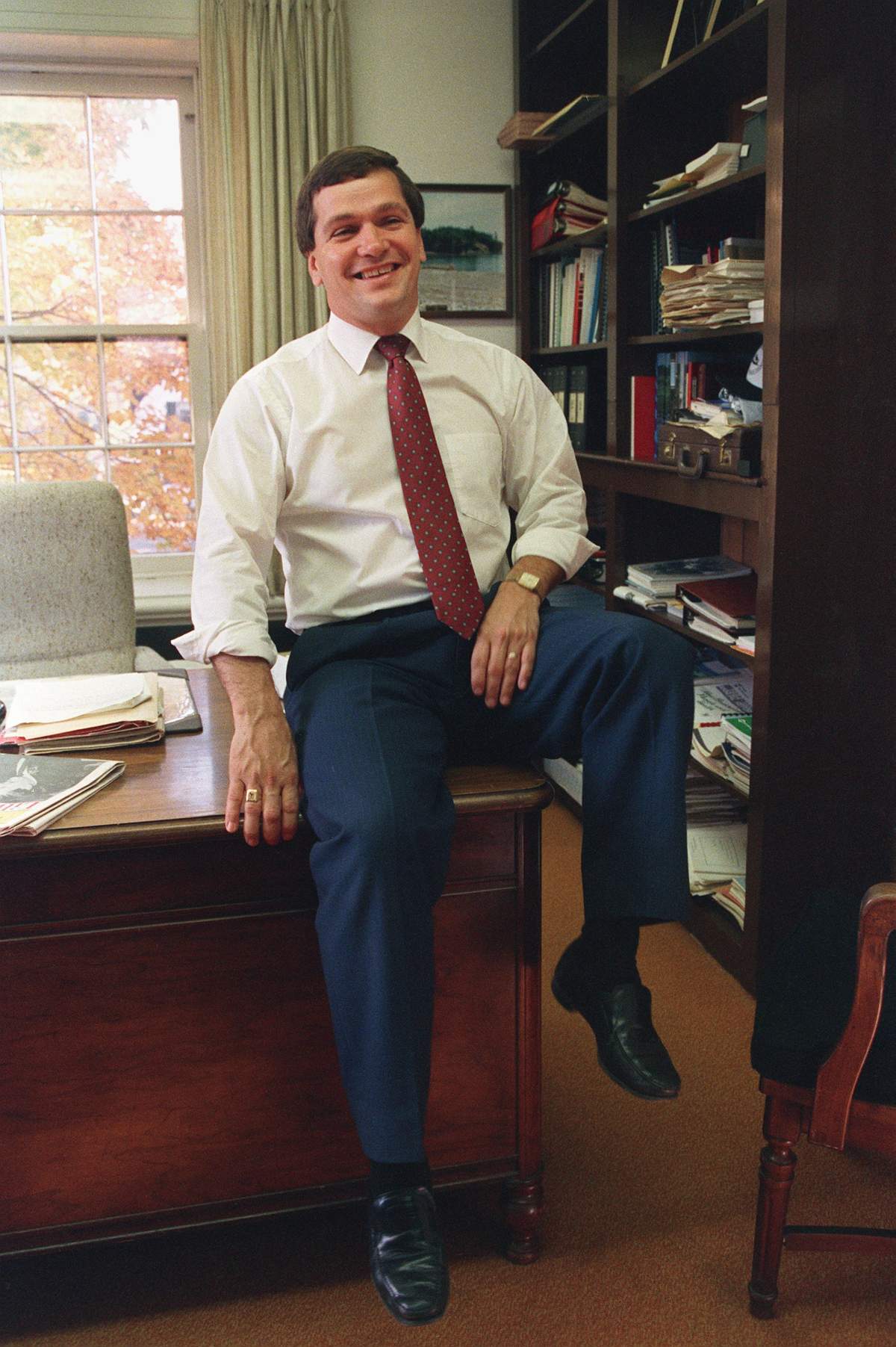New Brunswick Premier-elect Frank McKenna sits on the desk of the Leader of the Opposition at the Fredericton Legislature October 14, 1987. 
