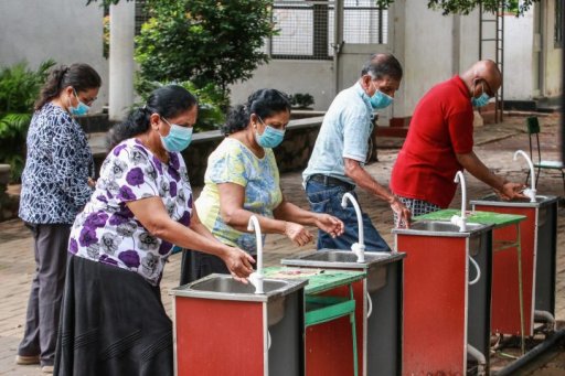 Sri Lanka voters wearing face mask and washing their hands as precautionary measures against coronavirus before casting their votes outside a polling station during the parliamentary election in Colombo.
