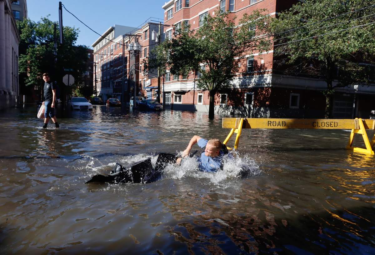 HOBOKEN, NJ – SEPTEMBER 2: A man falls off his bike into a flooded street the morning after the remnants of Hurricane Ida drenched the New York City and New Jersey area on September 2, 2021 in Hoboken, New Jersey. (Photo by Gary Hershorn/Getty Images)