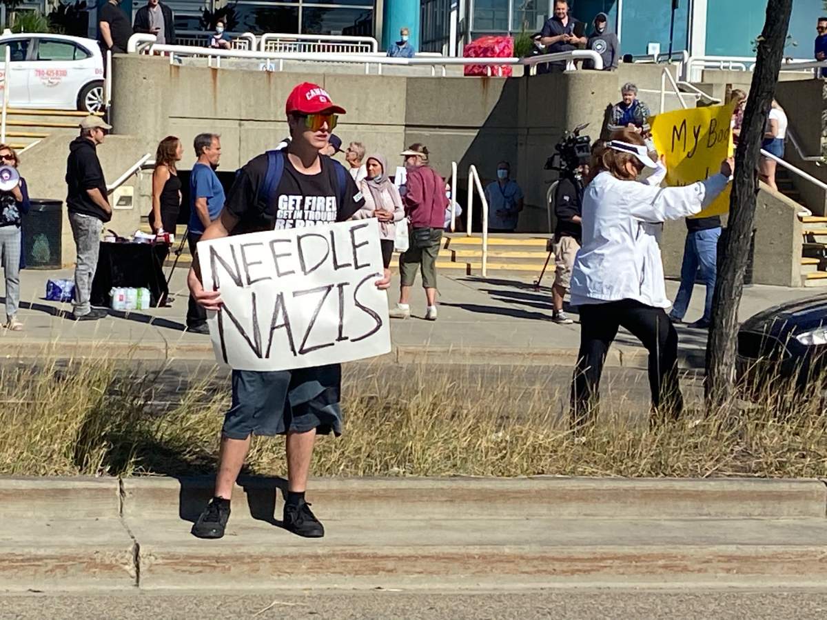 A protester holds a sign outside the Royal Alexandra Hospital in Edmonton.